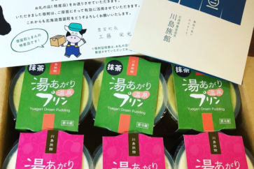 写真:ふわふわクリームをトッピング。湯治客に人気の湯あがりプリン