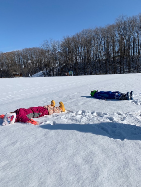 北海道の雪原で寝転ぶ人