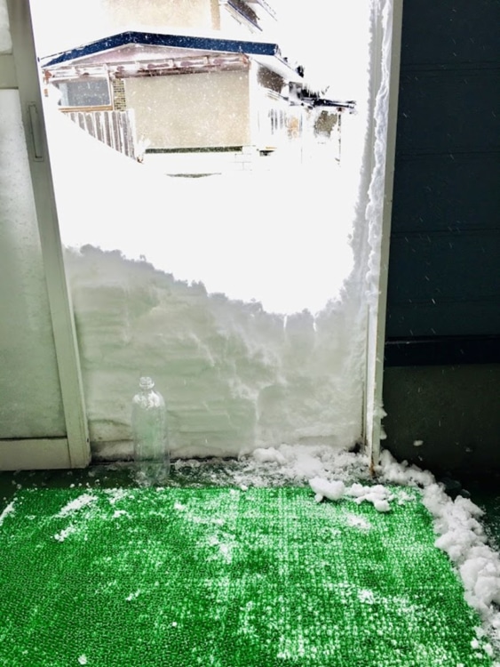 ドアをふさぐように積もった雪