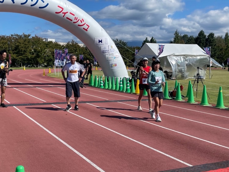 ゴールするランナーと野口さん