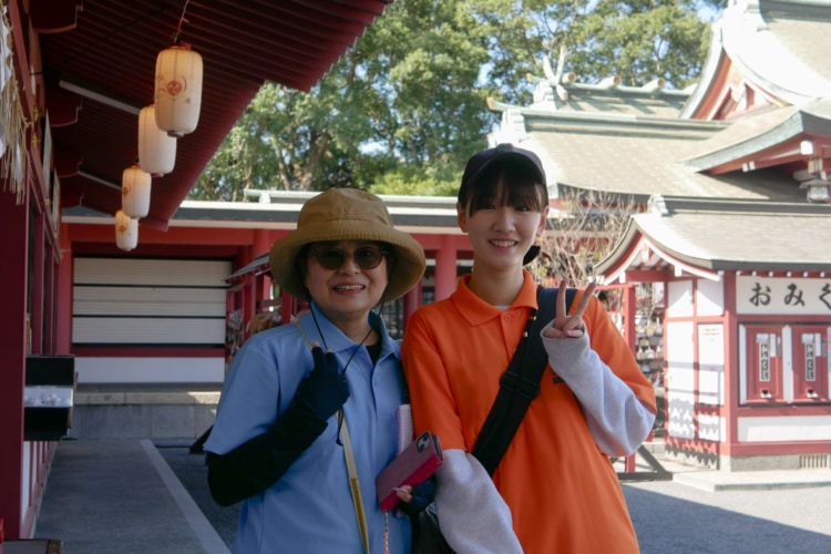 神社の境内でポーズをとる参加者たち