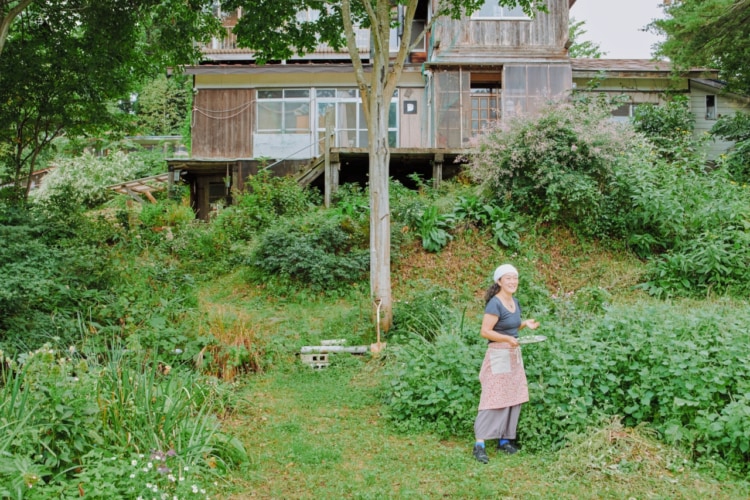 植物が生い茂る畑に立つ女性