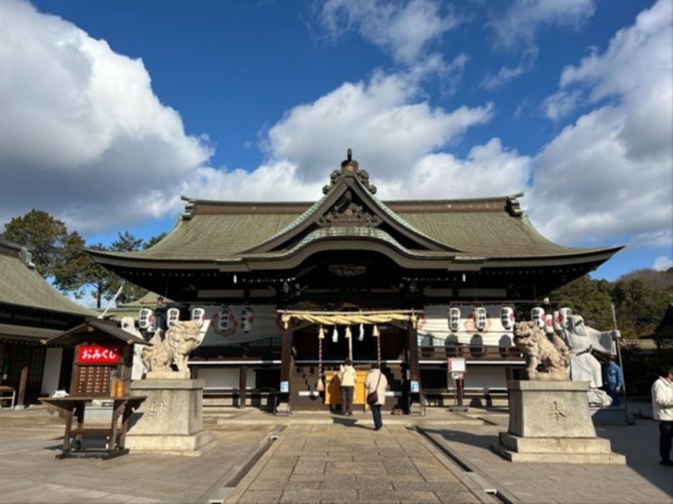 人がまばらな道通神社の拝殿。手前には狛犬が鎮座している