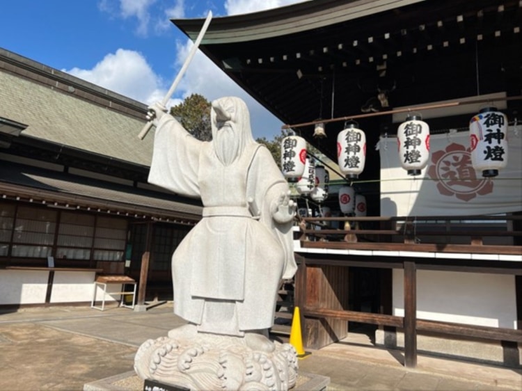 刀を持った右手を空に向かって突き刺すようにあげている猿田彦命の石像