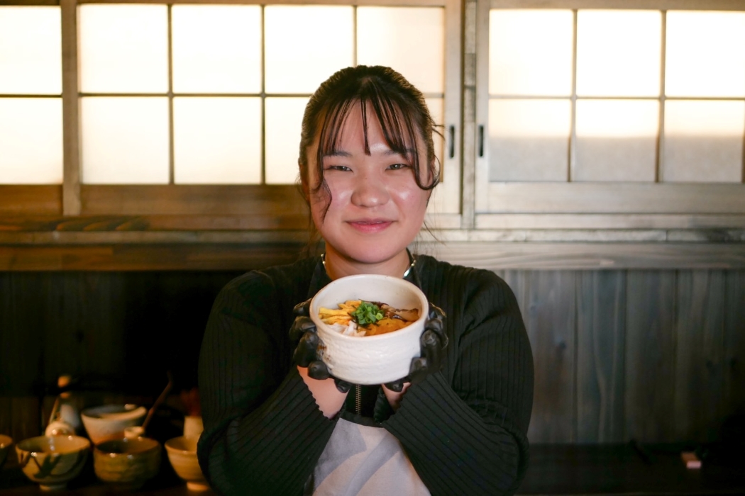 鶏飯を持った店主