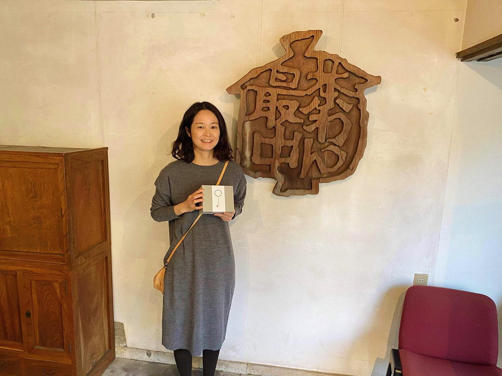 お菓子の箱を持って微笑む女性