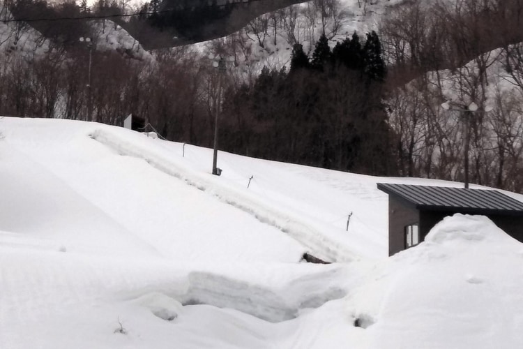 雪に埋もれているスノーボード用のハーフパイプ場