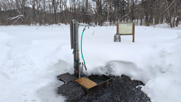 雪道のホースから出る湧き水