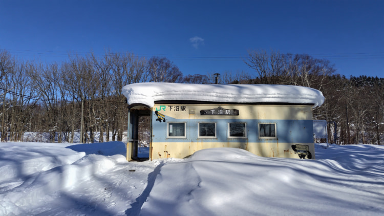 雪が積もる無人駅の駅舎