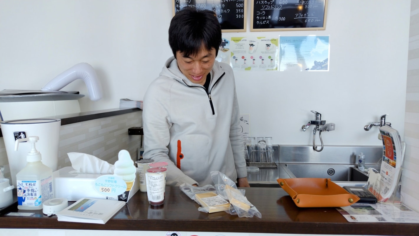 カウンター越しにチーズを出す男性