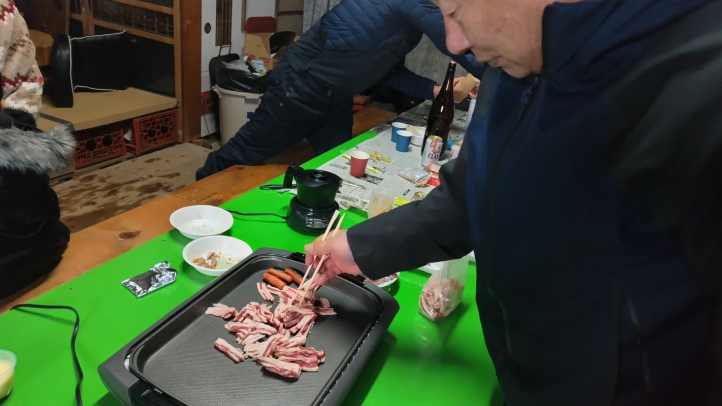 ホットプレートの上で肉を焼く男性