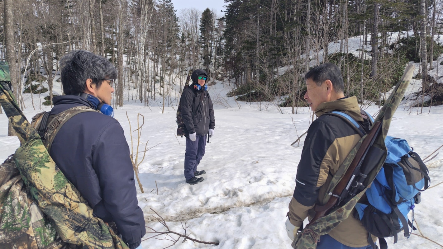 雪山を歩く3人の男性