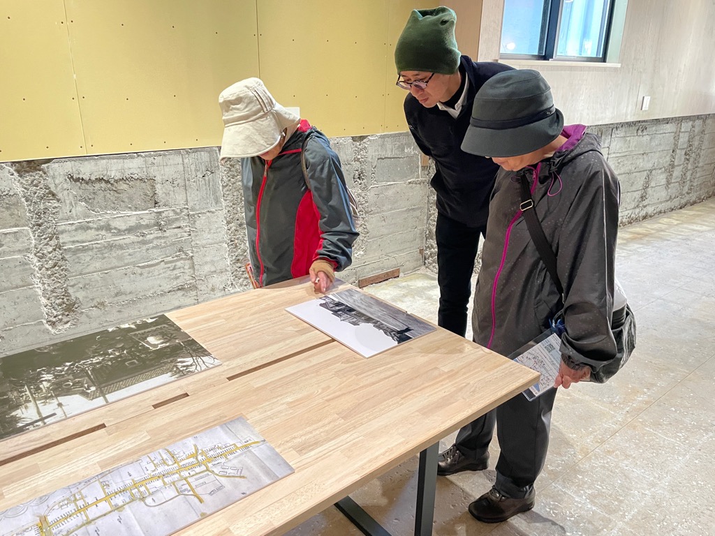 テーブルの上の展示物を見る人々