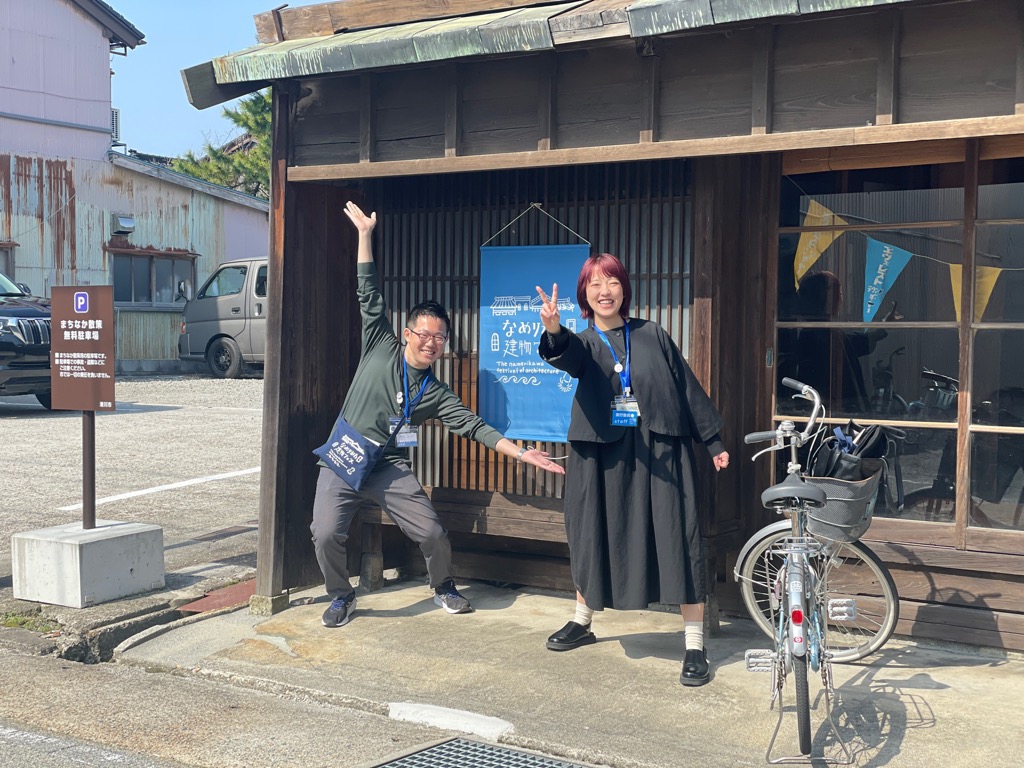 建物の前でピースサインをする男女