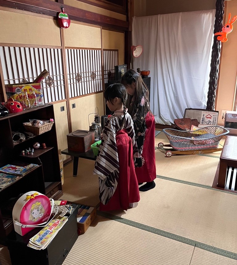 レトロな内装の室内で袴姿で遊ぶ2人の女の子