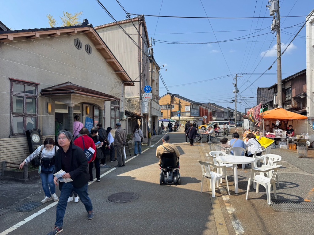 テーブルセットが置かれ、たくさんの人が行きかう路上