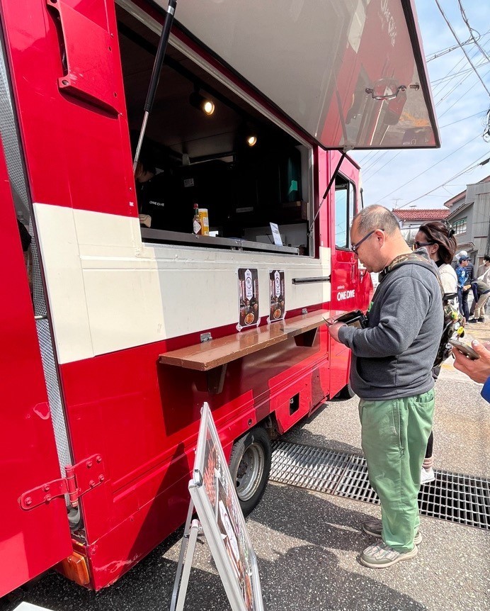 キッチンカーで食べ物を買う男性