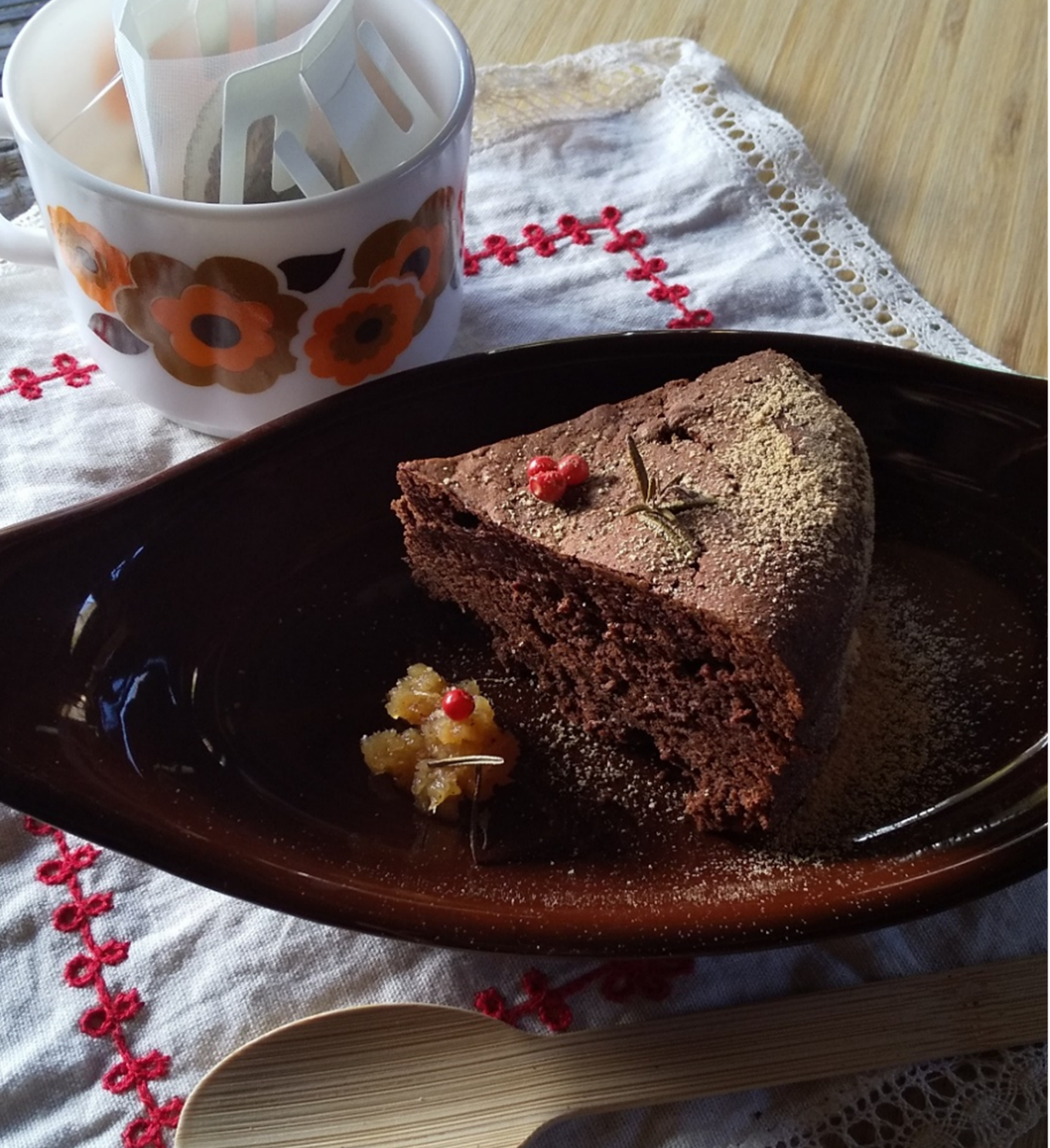 皿に盛られたガトーショコラケーキと、ドリップハーブティーが入った花柄のカップ